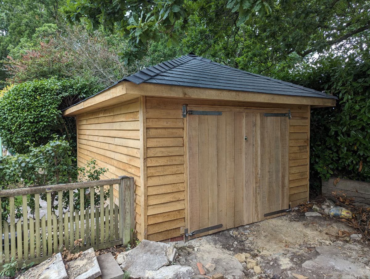Hipped roof workshop with slate tiles and double barn doors