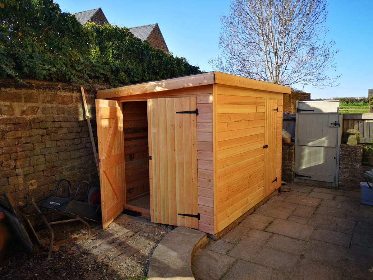 Garden shed with double doors and stone wall